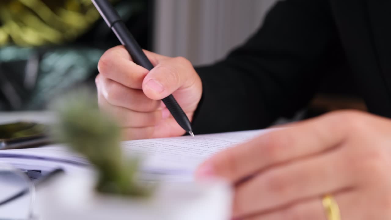 직장에서 비즈니스 문서를 작성하는 비즈니스 여성의 손의 클로즈업.