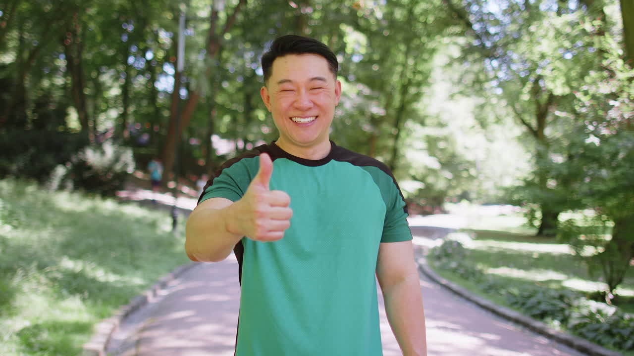 Athletic smiling runner fit man happy about marathon achievement showing thumb up like gesture