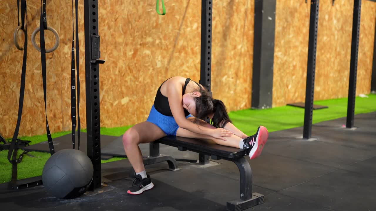 mujer estirándose en el gimnasio