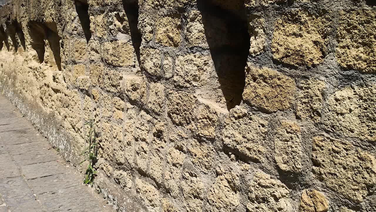 pared de piedra con ventanas estrechas en nápoles, italia