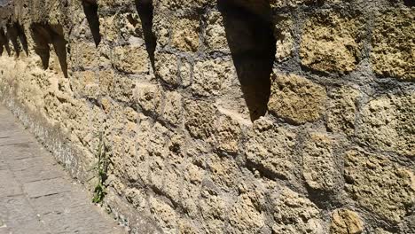 stone wall with narrow windows in napoli, italy