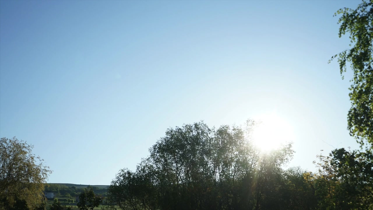 The sun rising on a clear blue sky timelapse daytime.