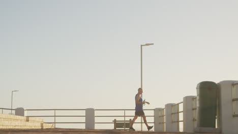 senior man performing stretching exercise on the promenade