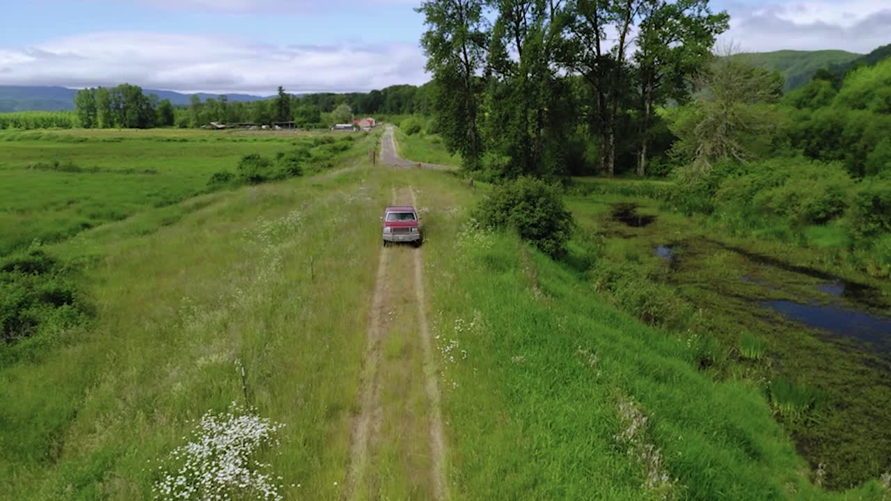 여름에 그린필드 사이를 오가는 빨간 트럭