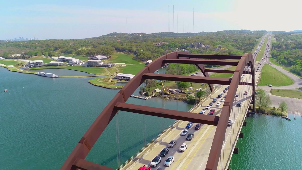 Biltrafikk over Pennybacker Bridge, med byen Austin, Texas øverst til venstre