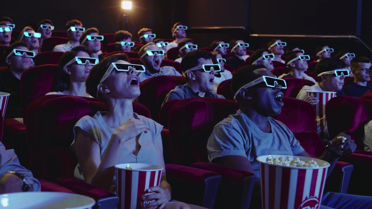 Pubblico con Occhiali 3D che Reagisce a un Film in un Cinema