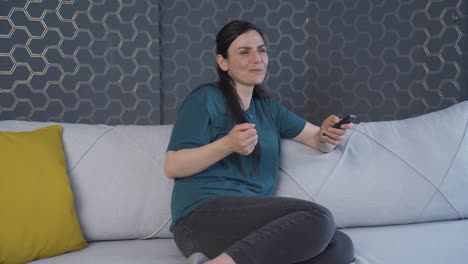 la mujer que mira la televisión se alegra.