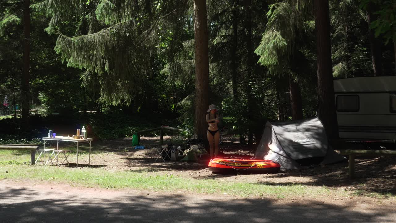 Sommer-Campingplatz an einem Waldsee mit Zelt, Kajak und Wohnmobil in Frankreich.