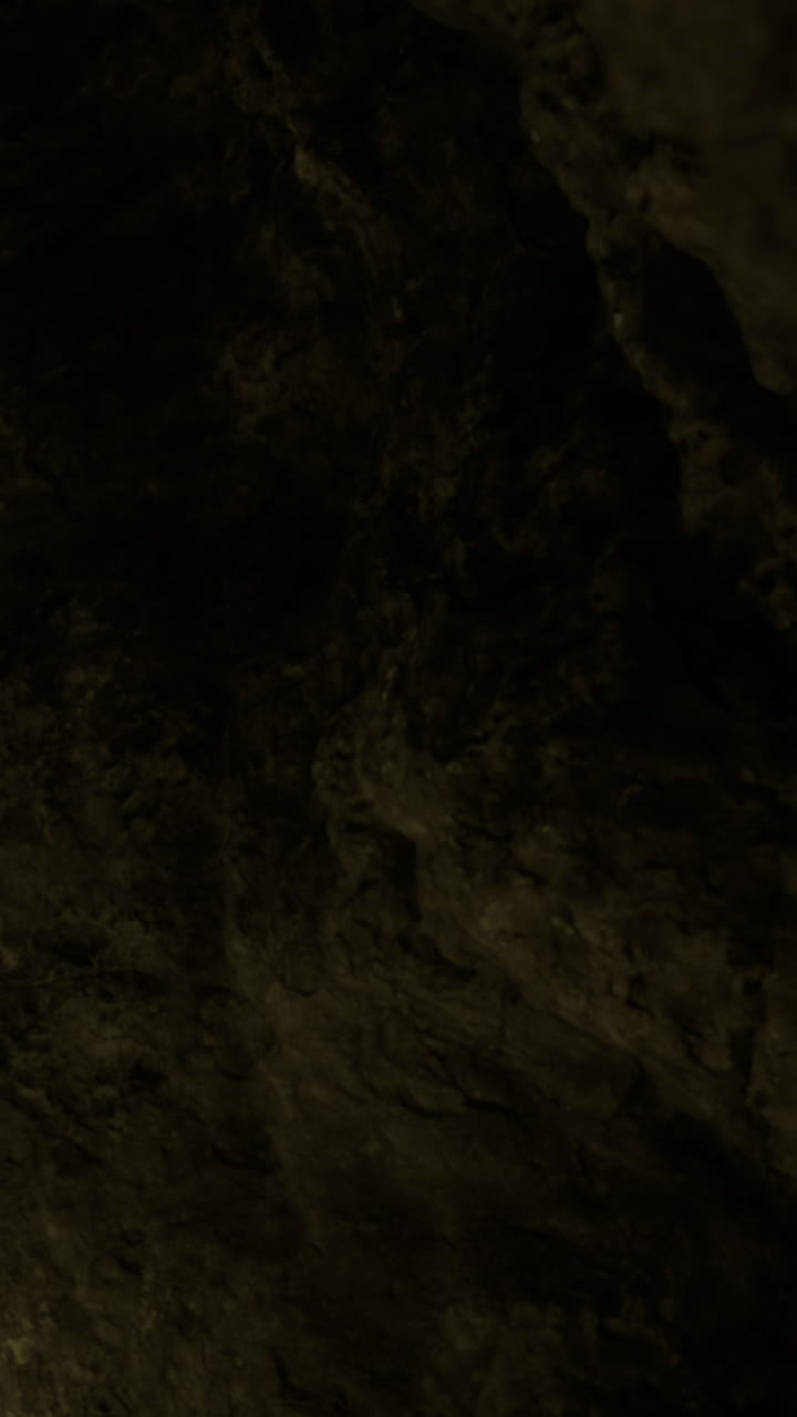 Esplorando la grotta buia e le sue texture rocciose sotto una luce fioca