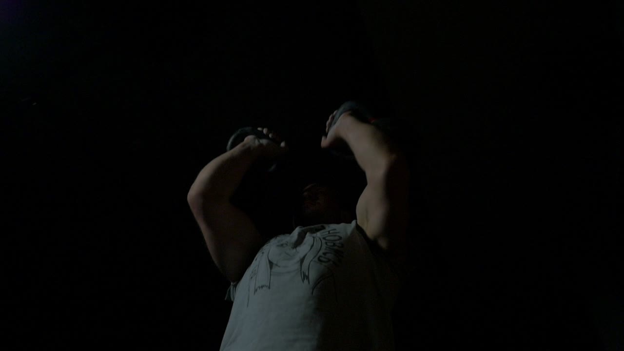 hombre realizando una prensa aérea de kettlebell