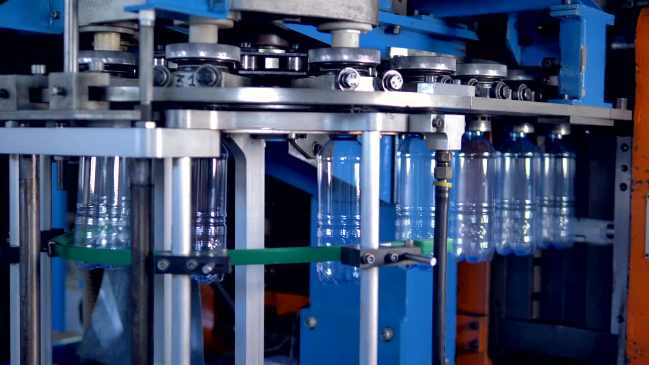 Plastic bottles cooled off and transferred on main guide rails.