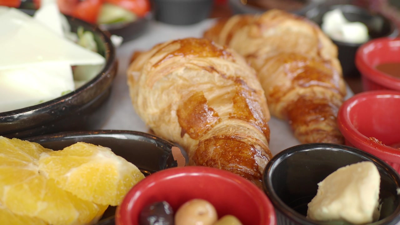 Appetizing Breakfast Platter with Golden Croissants and Orange Slices