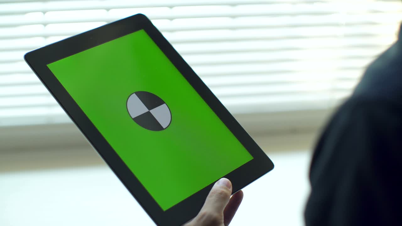 태블릿을 사용하는 사람.녹색 화면을 가진 태블릿