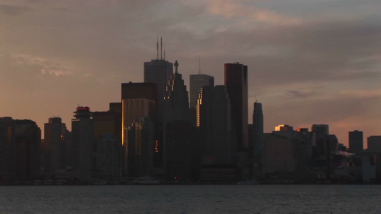 카메라는 토론토의 스카이라인을 패닝하고 cntower와 파스텔 하늘로 끝납니다.