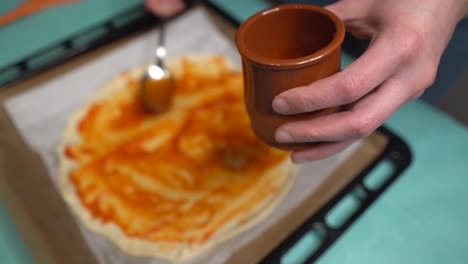 Selektiver-Fokus-Frau,-Die-Tomatensauce-Aus-Einem-Glas-Auf-Pizzateig-Legt