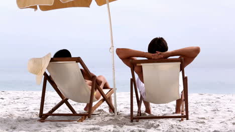 Couple-relaxing-under-parasol