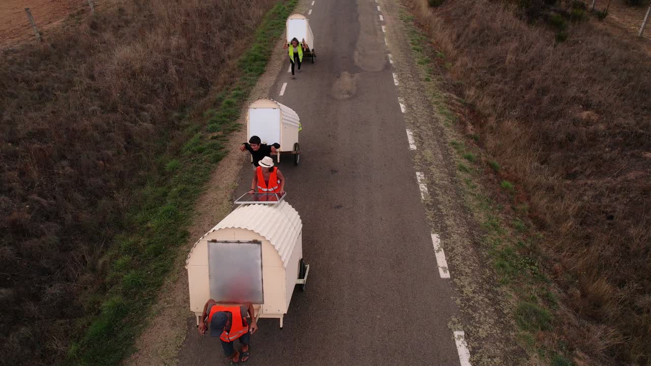 Famiglia nomade che traina piccole case su ruote in campagna in Spagna.