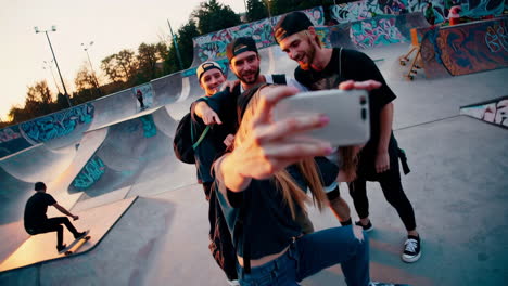young friends taking selfies at a skatepark during sunset