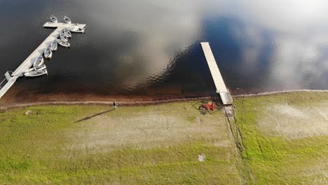 Aerial-downwards-shot-of-Wimbleball-Lake-Exmoor-UK-showing-a-beautiful-reflection-of-the-sky-with-moored-boats-at-the-side-of-the-lake