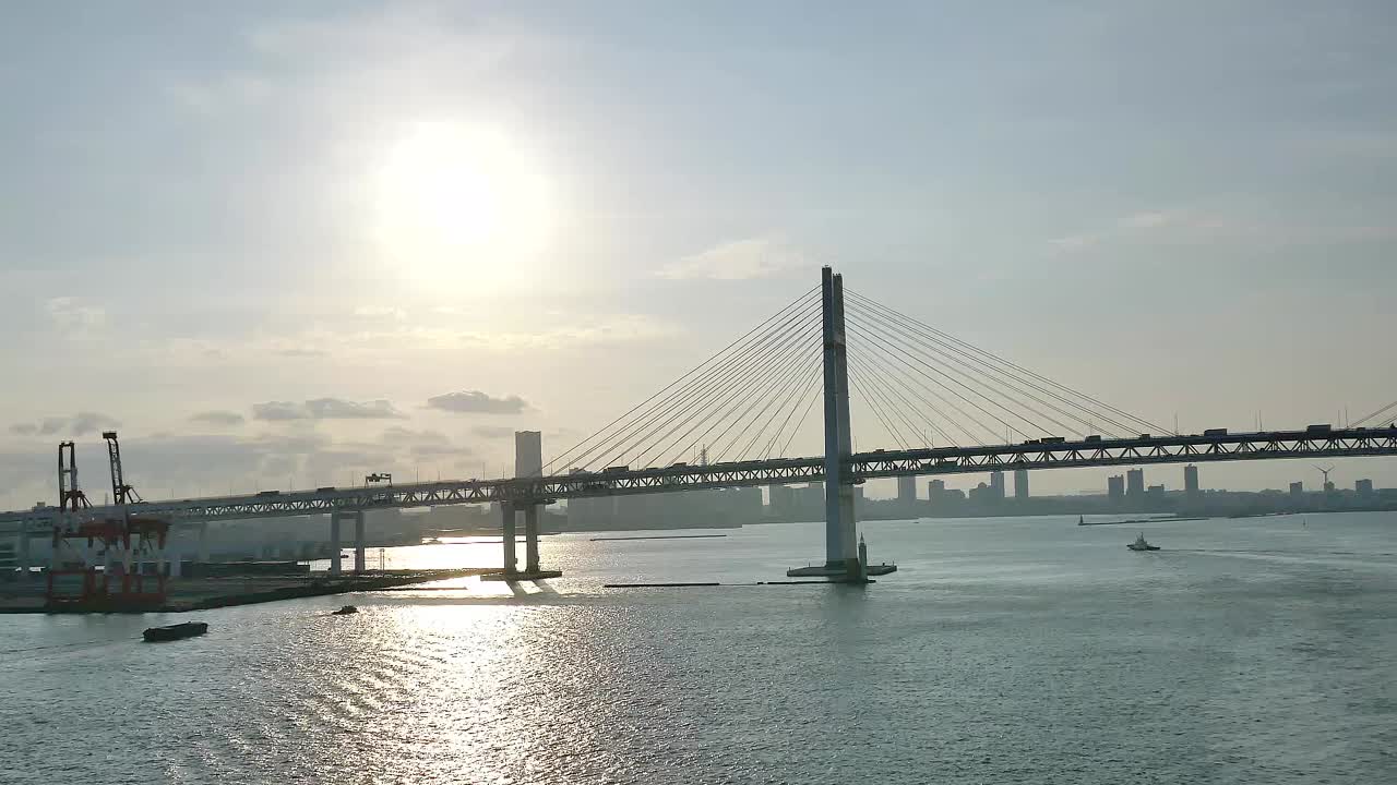 A wide shot of the Yokohama Bay Bridge taken from the cruise ship top deck, capturing ocean views and towering bridge spans