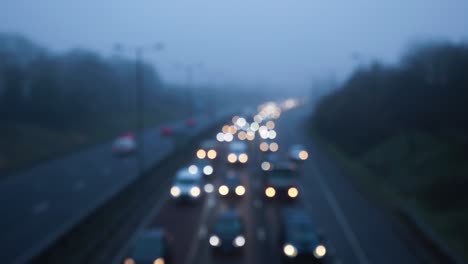 defocused slow traffic travelling in fog on a busy motorway in the uk