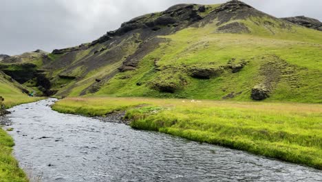 Grüne-Isländische-Landschaft-Mit-Fluss,-Der-An-Den-Skógar-Hügeln-Vorbeifließt,-Unter-Bewölktem-Himmel