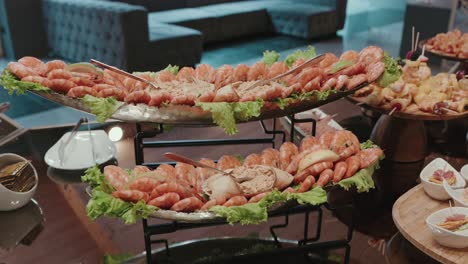 cold seafood appetizer display featuring shrimp and dips on tiered trays