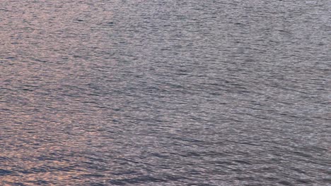 Fog-over-sea-and-seaside-town-at-sunrise-with-calm-water-and-colourful-sky