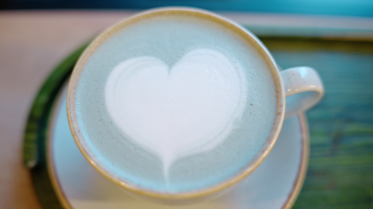 Top down shot of foam latte art on blue matcha drink
