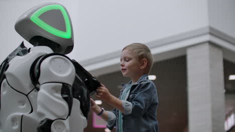 Humanoid robot talks with child at technology exhibition. The Exhibition Park Of Robots. Humanoid robot talks with