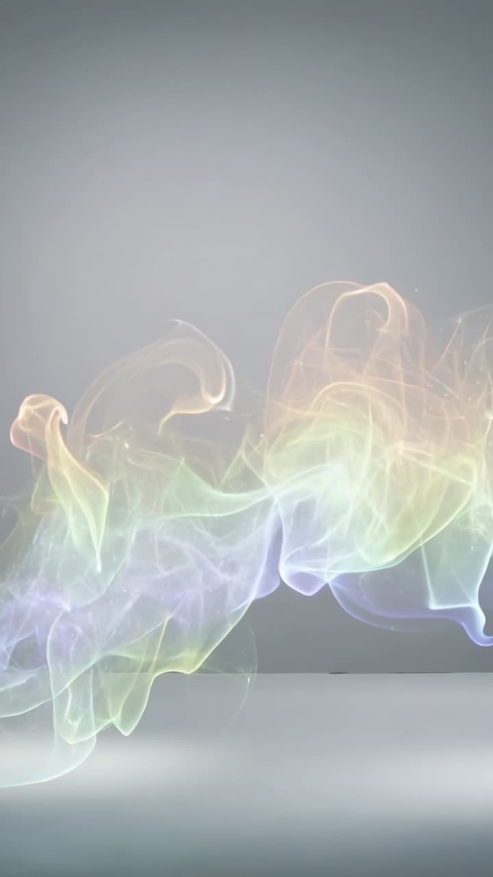 Vertical video: Flowing on play rainbow vapor ribbon curling over gray floor, showcasing sparkles