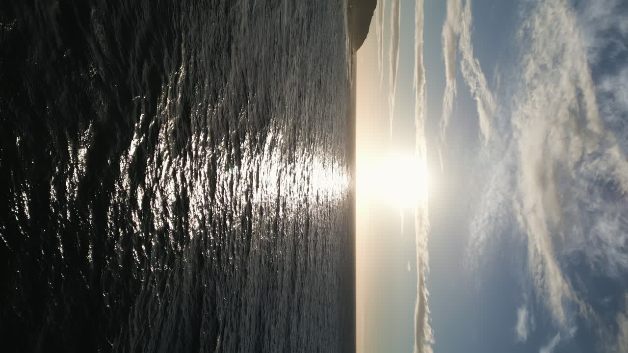 하와이 오아후 의 모래 해변 에서 파도 위 로 떠오르는 태양 의 수직  ⁇