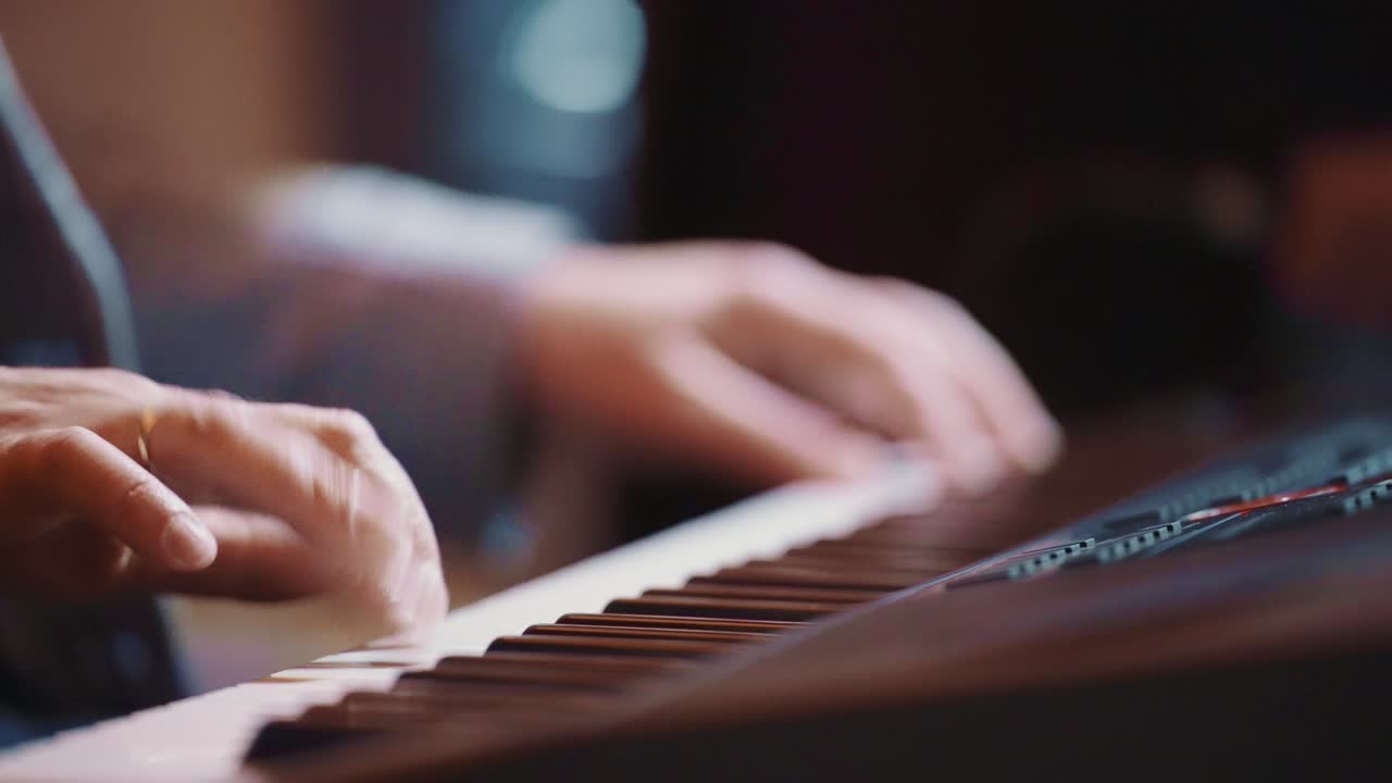 Close-up of Musician's Hands Playing Piano Keys