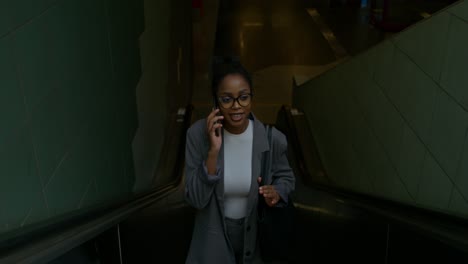 mujer de negocios en una escalera mecánica