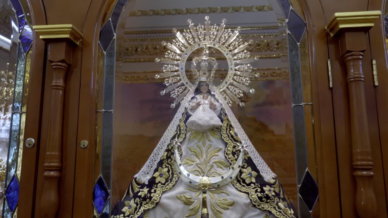 Estatua religiosa de la Virgen María exhibida dentro de una iglesia católica decorada en Cholula, Puebla, México, con una arquitectura de altar ornamentada.