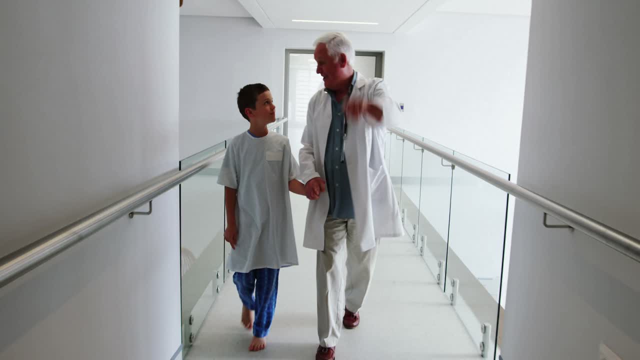 Doctor interacting with patient while walking in corridor