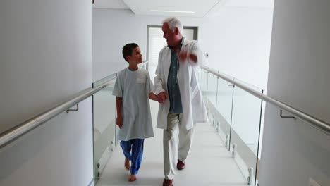 doctor interacting with patient while walking in corridor