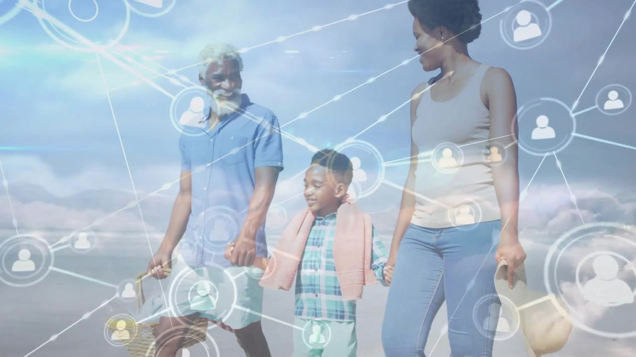 Family walking holding hands on beach as network overlay emerging from adults' heads, linking trio