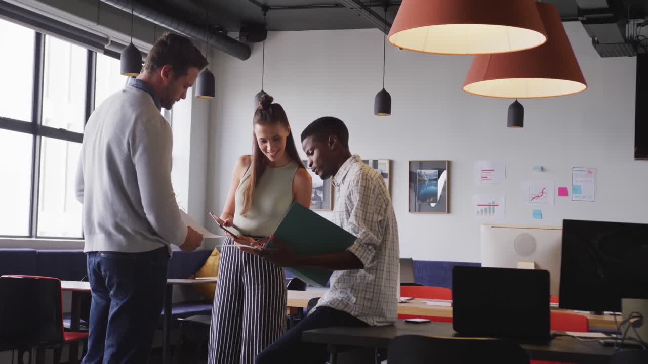 Felici e diversi professionisti che discutono di lavoro durante una riunione in ufficio.