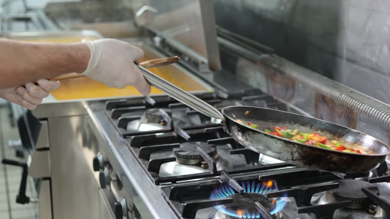 Misturando legumes fatiados em uma frigideira em câmera lenta, vídeo 4k