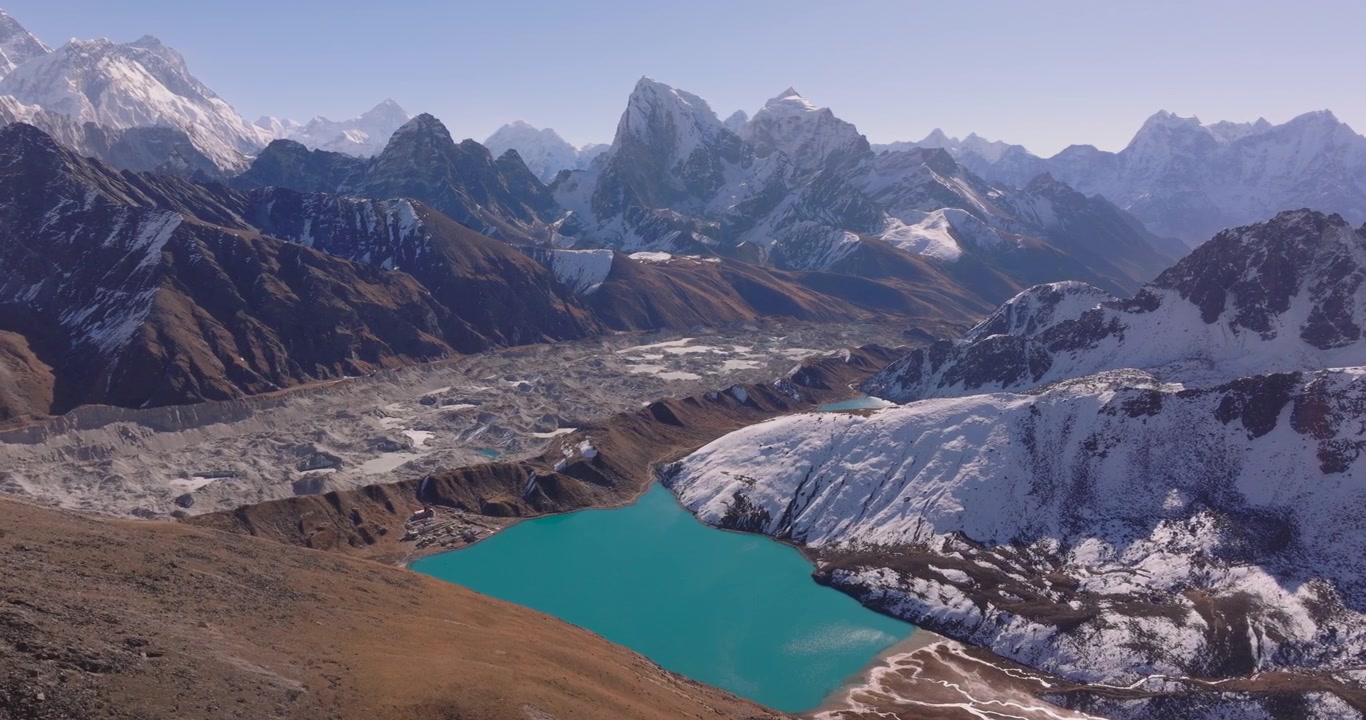 Nepal, Everest bölgesindeki Gokyo Gölü'nün drone çekimi: engebeli Ngozumpa Buzulu ve Khumbu bölgesinin karla kaplı zirvelerinin altında yer alan canlı turkuaz göl.