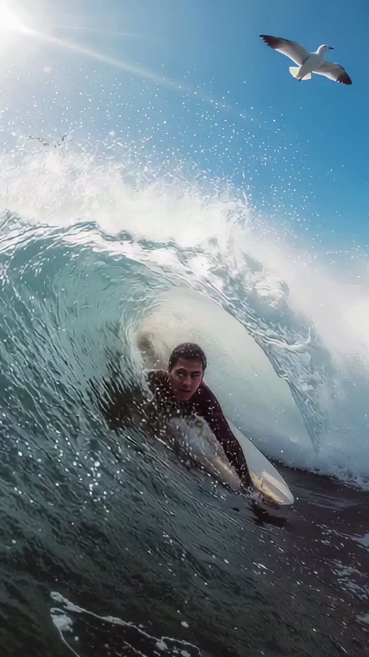 Video verticale: un'onda che si infrange e spinge un surfista a ripararsi e a cavalcare il tubo a riva, muta, tavola