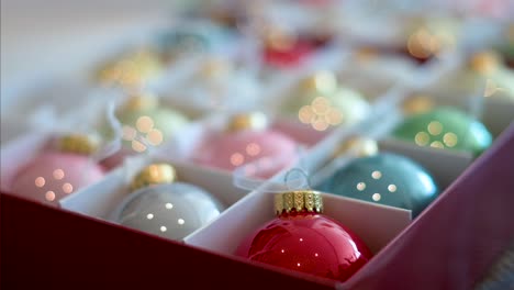 Precise-focus-on-a-vibrant-red-Christmas-bauble,-with-other-colors-softly-fading-into-the-background-within-the-box