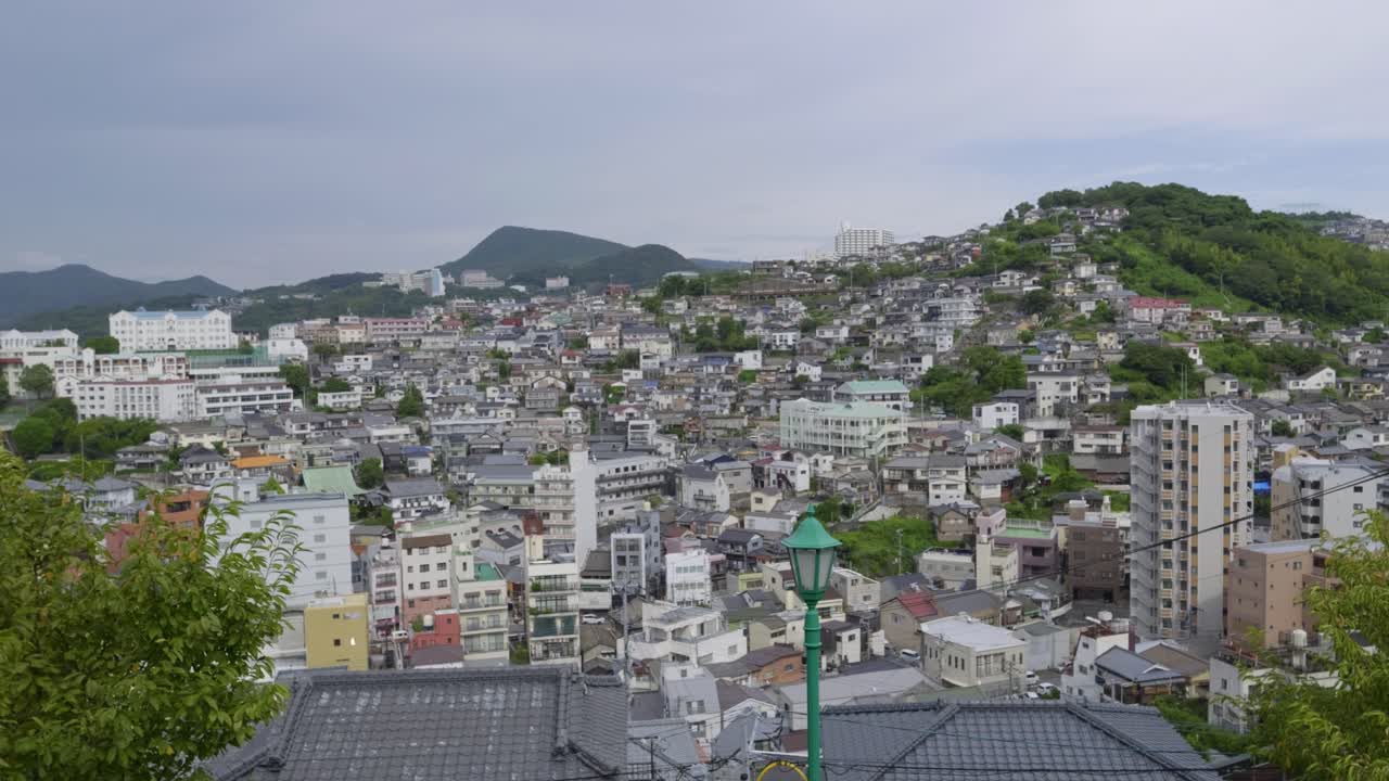 Slow motion panning shot over hills of Nagasaki City from high above viewpoint