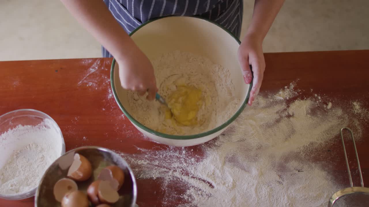 Midsection of caucasian woman baking in kitchen