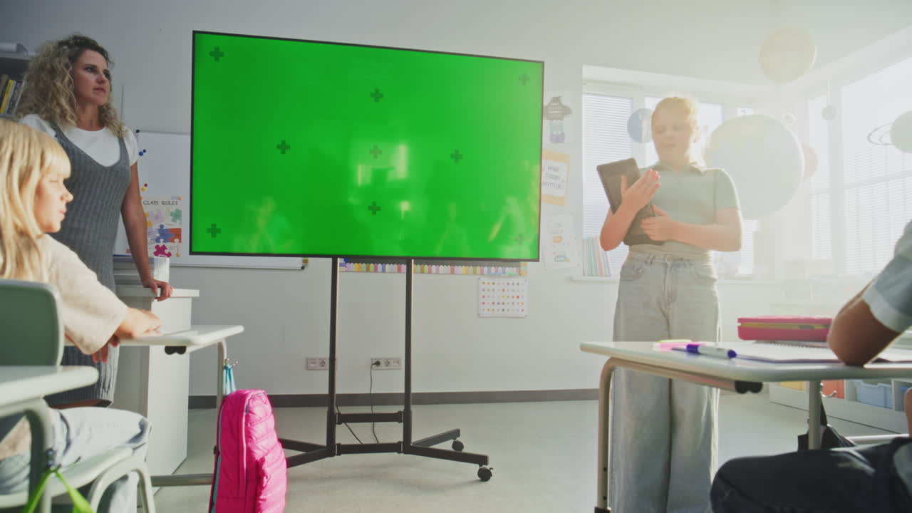 Primary School Girl with Tablet Computer Showcasing Knowledge Digital Screen with Chromakey Mockup