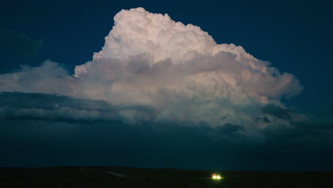 dramatic cumulonimbus cloud at night with distant vehicle headlights