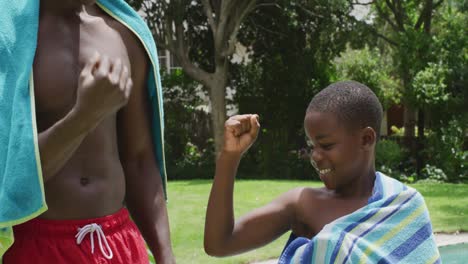 feliz padre y hijo afroamericanos limpiando con toallas en la piscina