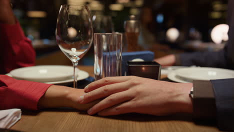 romantic couple holding hands in luxury interior restaurant. dating concept.