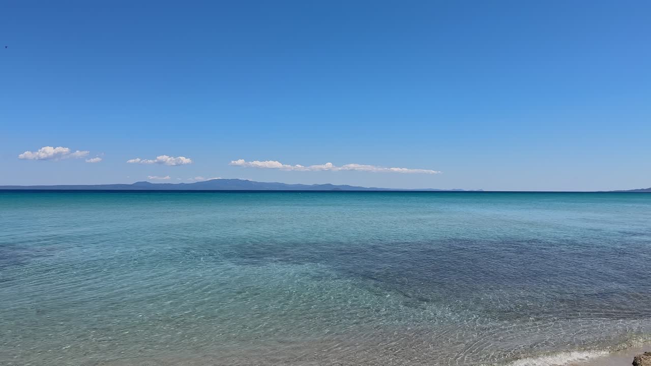 Stunning beach scene in Halkidiki, Greece, with elegant sunbeds facing the crystal-clear turquoise sea. A perfect summer escape in the heart of the Aegean.